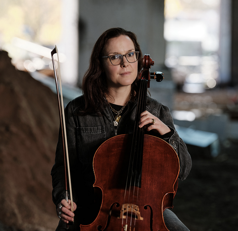 A seated woman holding a cello